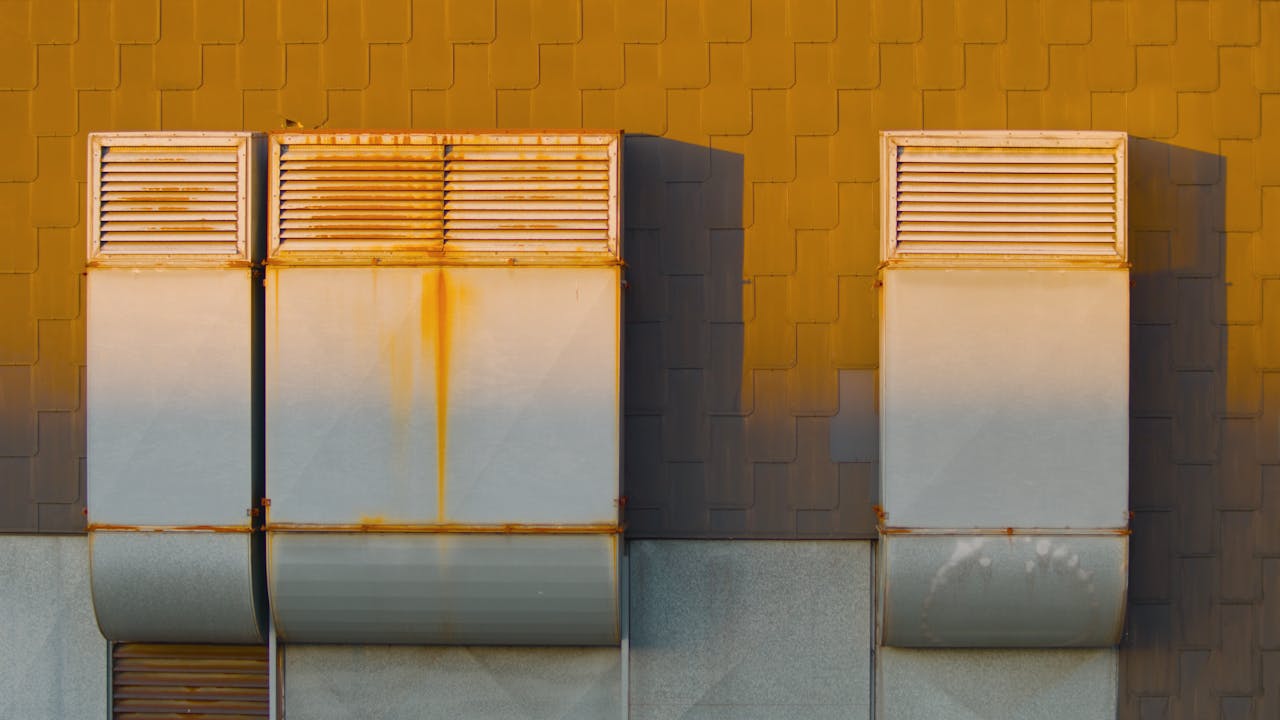 Close-up of industrial ventilation ducts with rust at sunrise in Essen, Germany.