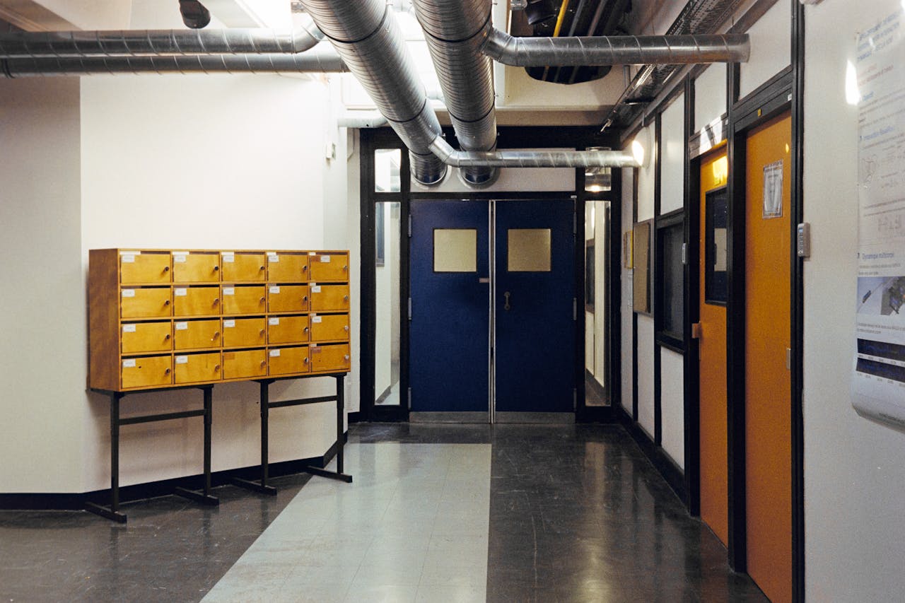 about-us Industrial hallway in Compiègne, France, featuring metal ducts and wooden lockers.